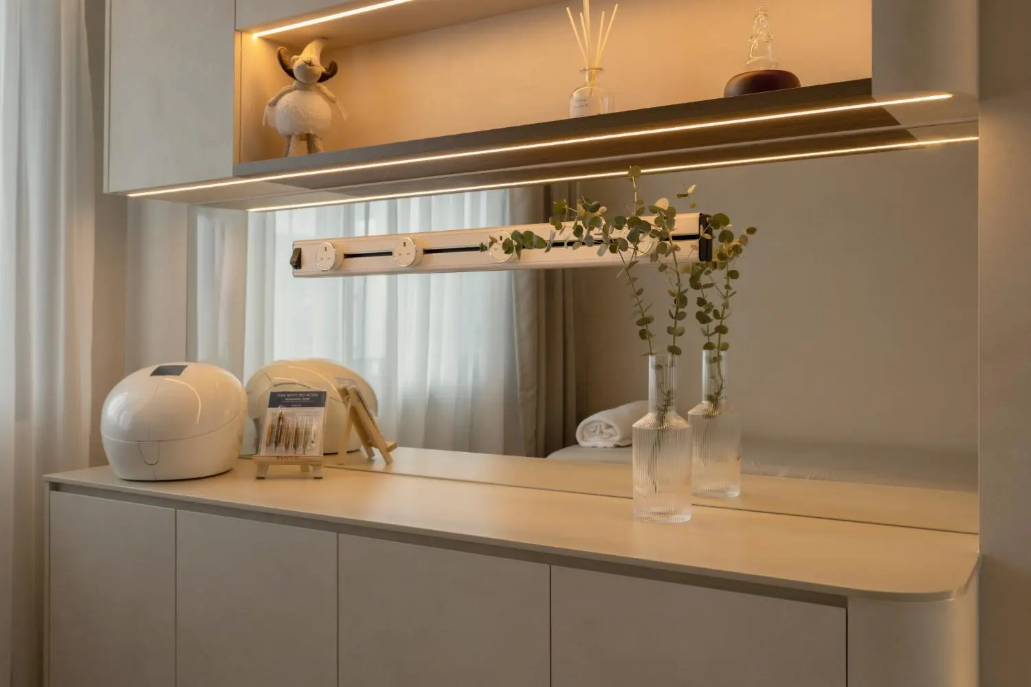 Dressing vanity close-up — backlit shelf, mirror, eucalyptus and ceramic objects