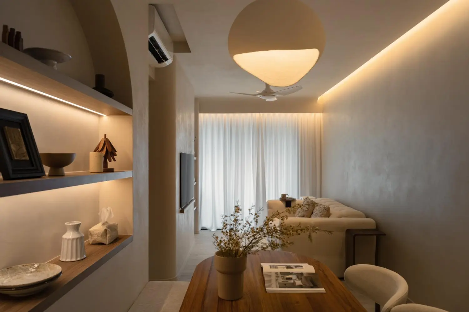 Living room — lit display niche, sofa, globe pendant and limewash walls